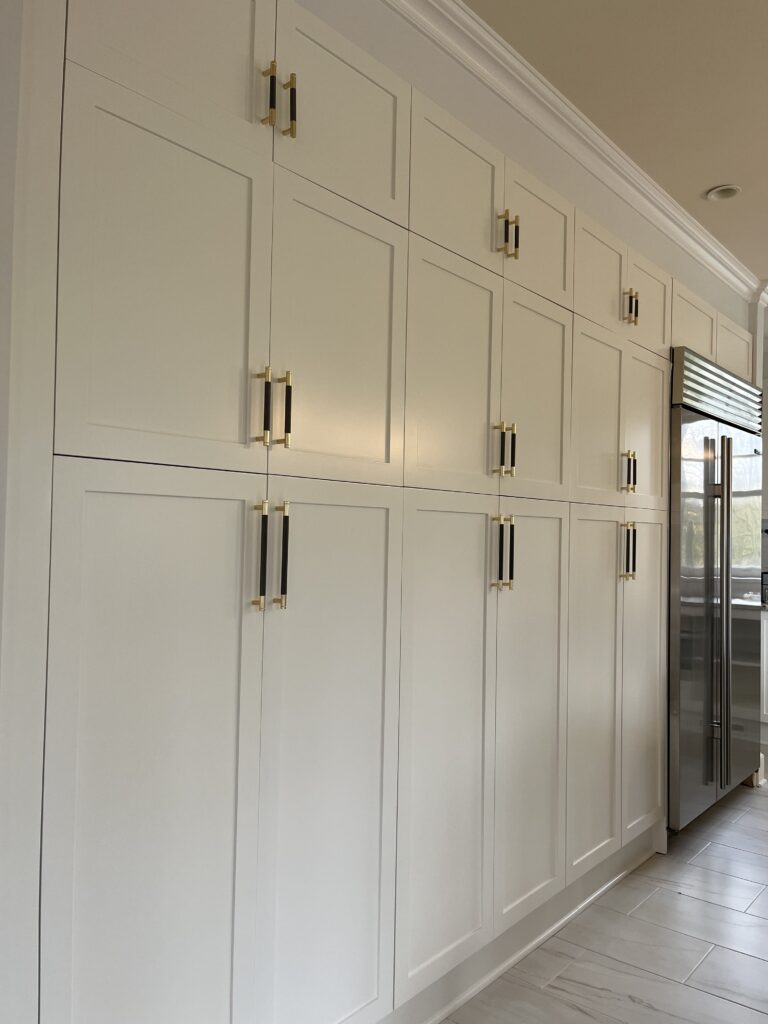 Cabinet painting project in Greenwich CT with tall white cabinetry and polished custom finish