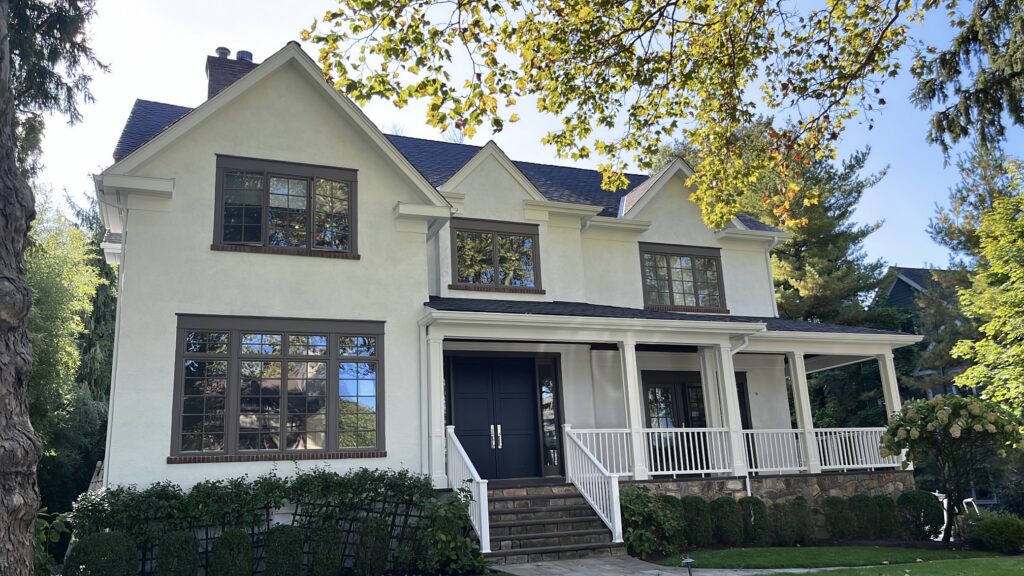 Exterior painting project in Scarsdale NY with light stucco, dark trim, and refreshed porch detail